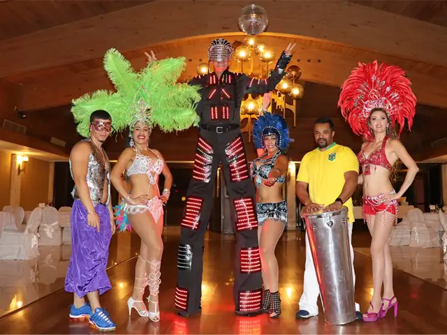 Hora Loca party performers for hire in Miami, FL, featuring a tall LED robot stilt walker, colorful Brazilian samba dancers with feathered headdresses, and a live drummer from StepFlix Entertainment.